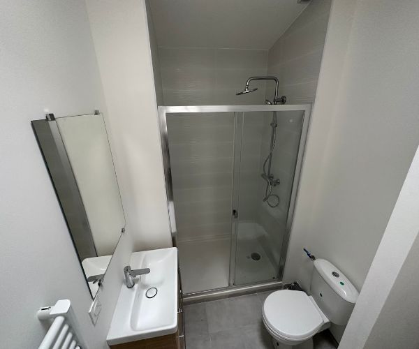 Salle de bain rénovée avec douche dans un appartement en immeuble intramuros